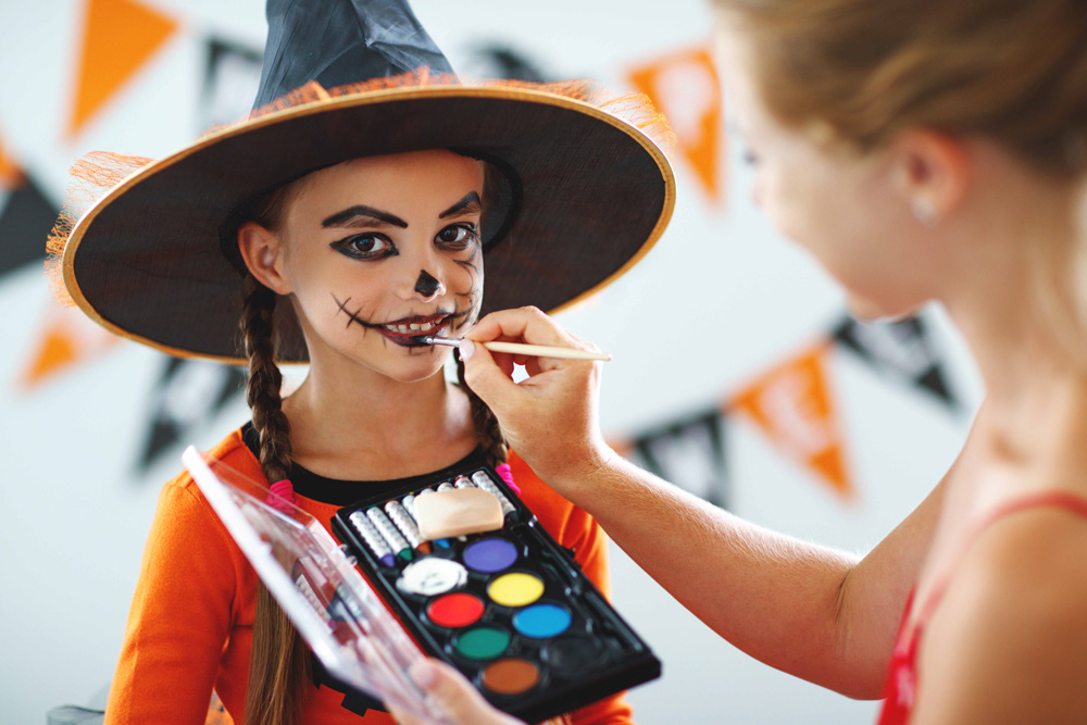 little girl getting face painting done for halloween