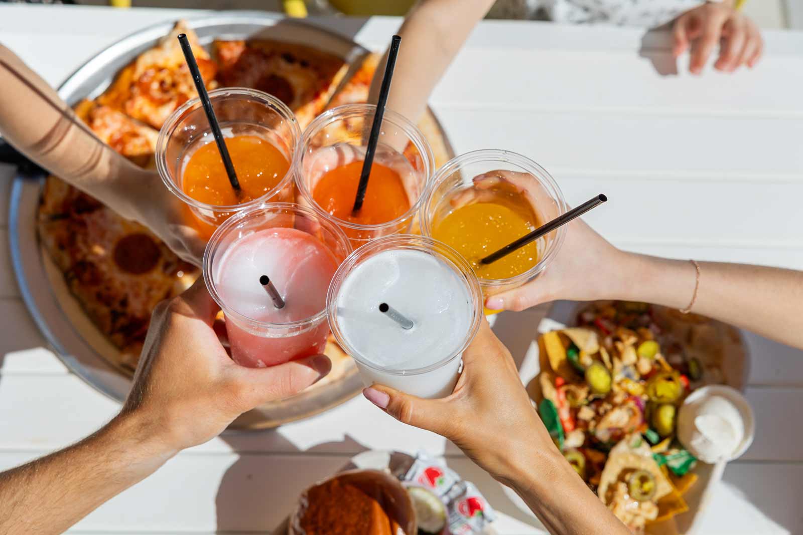 a group clinking glasses with food on the table