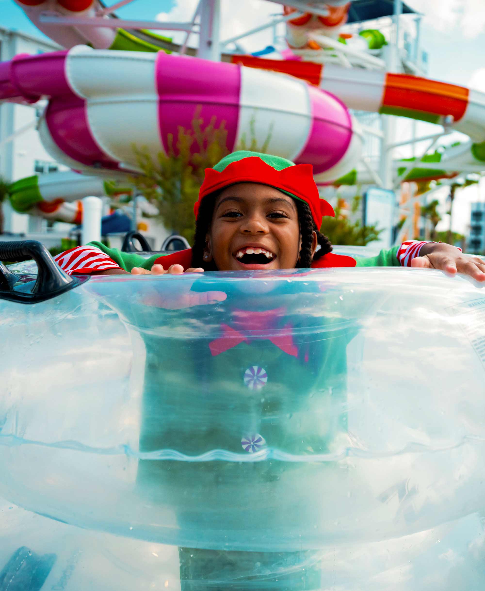 kid in elf costume in an innertube at the water park