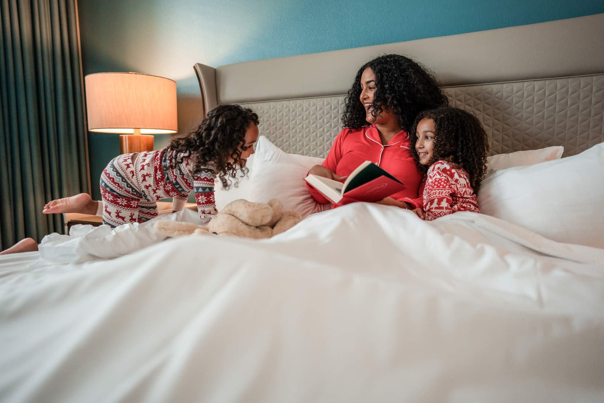 mom reading to kids in bed