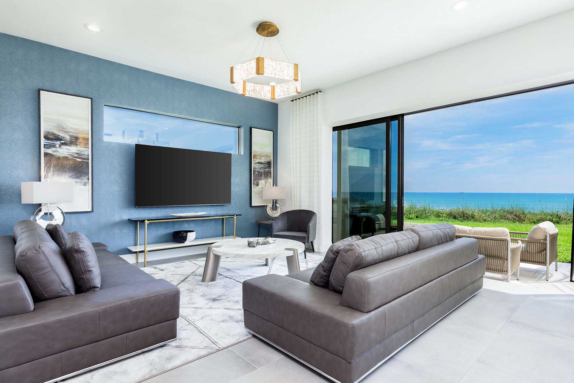 living room view in villa with screen doors open and view of beach
