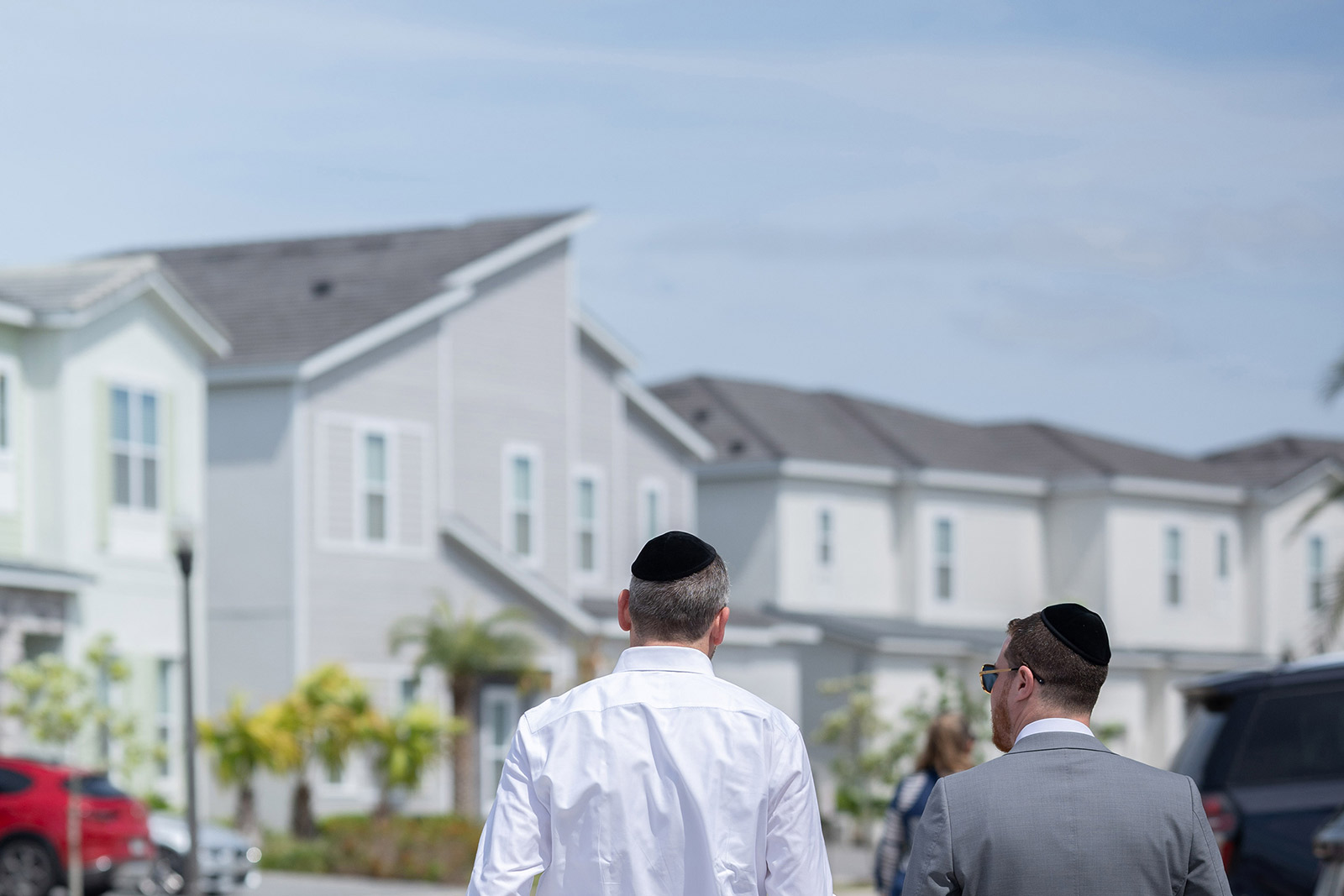 2 men walking down the street in front of homes in Villatel Village