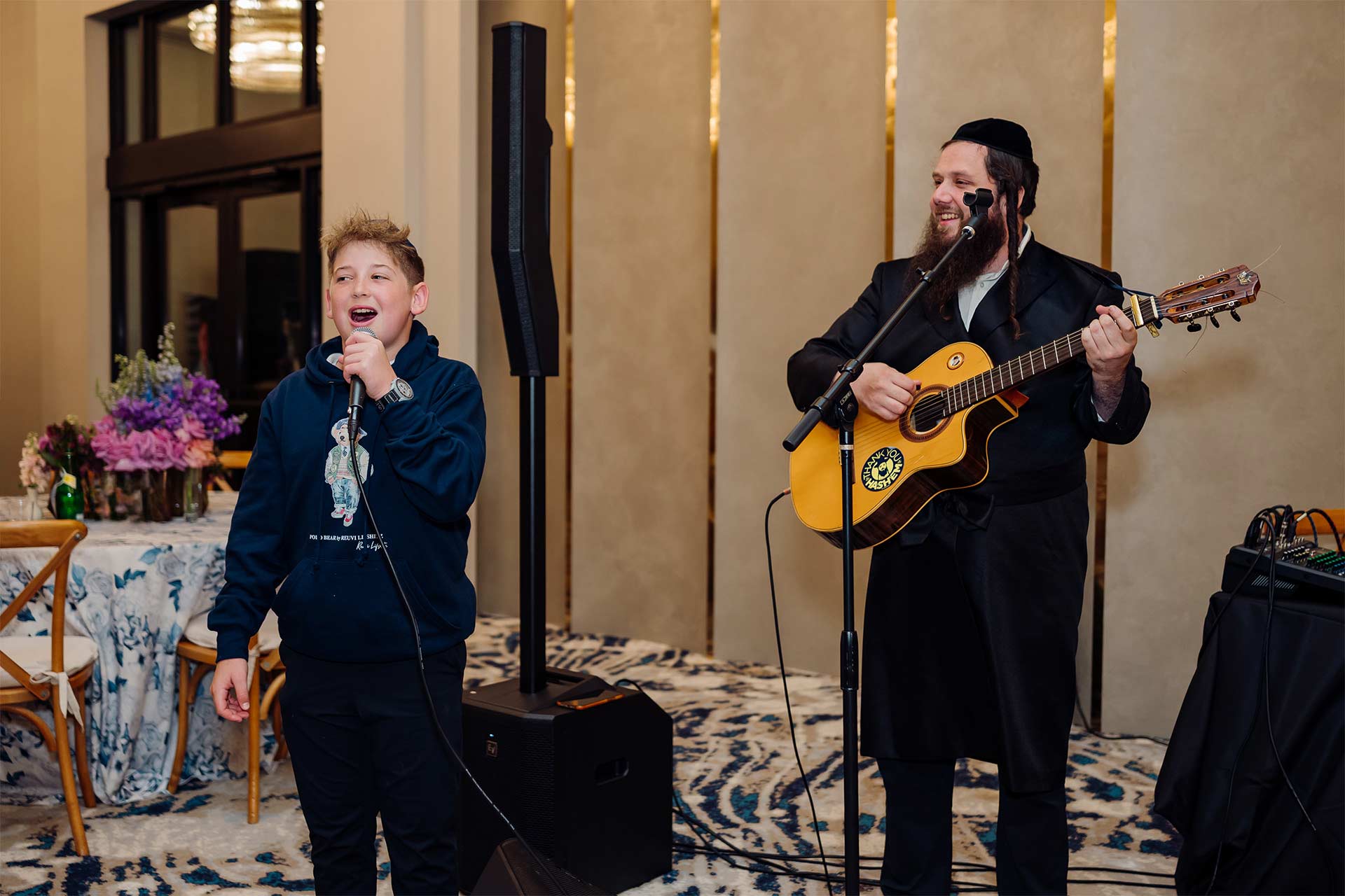 concert with a man playing guitar and boy singing for pesach in florida at villatel village