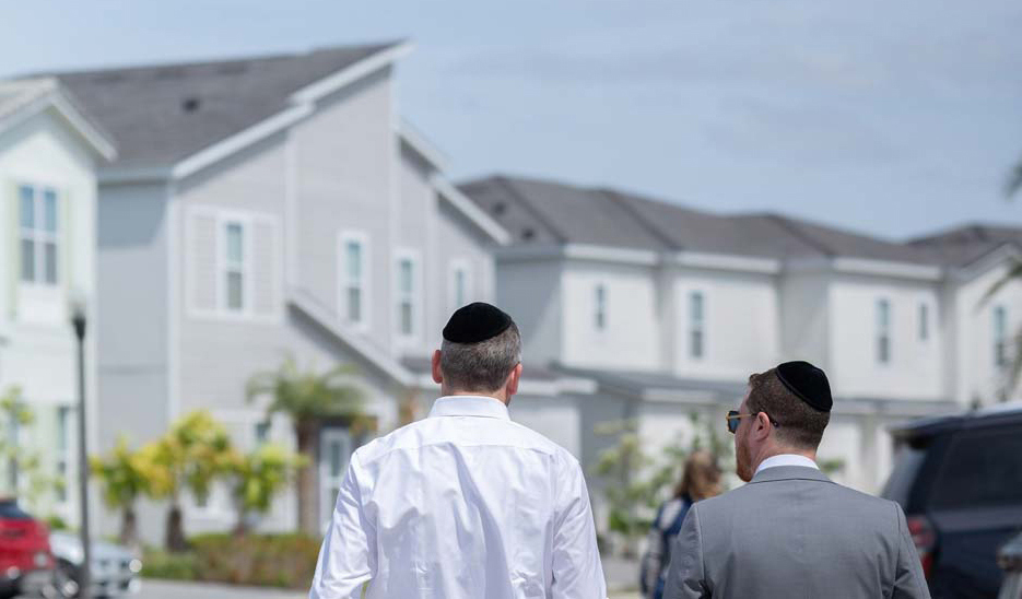men wearing yarmulkes in front of villas for pesach in florida at villatel orlando resort